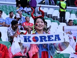 Suporter wanita Korea Selatan membentangkan syal bertuliskan Korea saat memberikan dukungan kepada timnas kesayangan mereka yang bertanding melawan Uruguay pada laga grup H Piala Dunia 2022 di Education City Stadium di Al Rayyan, Qatar, Kamis (24/11/2022). Harry Langer/DeFodi Images/Getty Images 