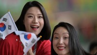 Senyuman manis dan menawan suporter Korea Selatan saat memberikan dukungan kepada timnas Korsel saat melawan Uruguay. Salih Zeki Fazlioglu/Anadolu Agency/Getty Images 