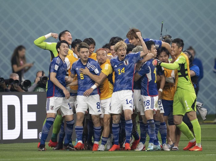 DOHA, QATAR - NOVEMBER 23: Ritsu Doan is swamped by his team-mates after scoring Japans first goal during the FIFA World Cup Qatar 2022 Group E match between Germany and Japan at Khalifa International Stadium on November 23, 2022 in Doha, Qatar. (Photo by Sebastian Frej/MB Media/Getty Images)