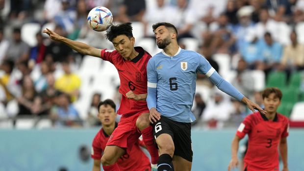 South Korea's Hwang In-beom, left, jumps for the ball with Uruguay's Rodrigo Bentancur during the World Cup group H soccer match between Uruguay and South Korea, at the Education City Stadium in Al Rayyan , Qatar, Thursday, Nov. 24, 2022. (AP Photo/Lee Jin-man)