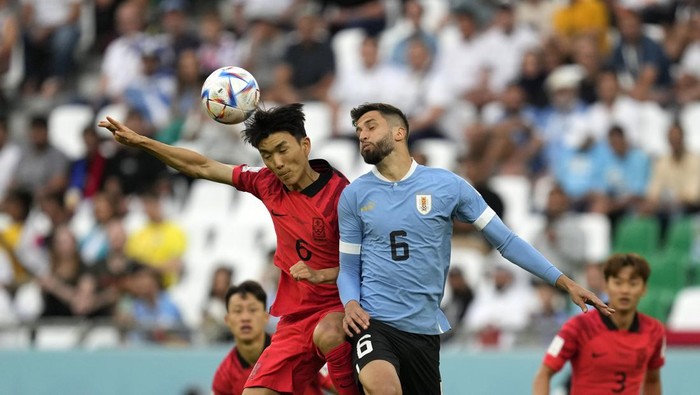 South Koreas Hwang In-beom, left, jumps for the ball with Uruguays Rodrigo Bentancur during the World Cup group H soccer match between Uruguay and South Korea, at the Education City Stadium in Al Rayyan , Qatar, Thursday, Nov. 24, 2022. (AP Photo/Lee Jin-man)