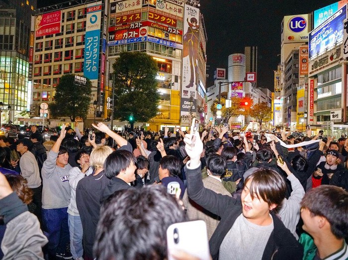 People celebrate at Shibuya crossing in Tokyo, as Japan's national soccer team won against Germany in the World Cup in Qatar, early Thursday, Nov. 24, 2022.(Kyodo News via AP)