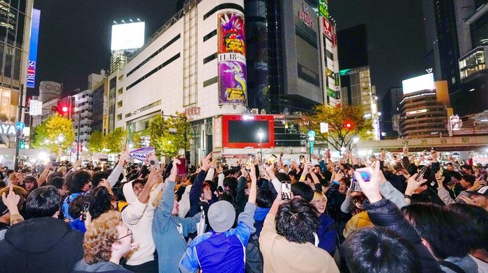 People celebrate at Shibuya crossing in Tokyo, as Japan's national soccer team won against Germany in the World Cup in Qatar, early Thursday, Nov. 24, 2022.(Kyodo News via AP)