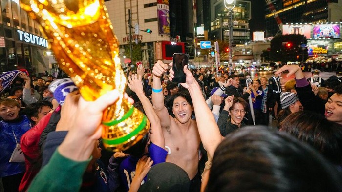 Warga Tokyo Pestapora Usai Timnas Jepang Libas Jerman 2-1 People celebrate at Shibuya crossing in Tokyo, as Japan's national soccer team won against Germany in the World Cup in Qatar, early Thursday, Nov. 24, 2022.(Kyodo News via AP)