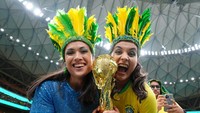 Dengan memakai topi bulu uniknya, mereka membawa replika Piala Dunia selama memberi dukungan kepada timnas Brasil. Nick Potts/PA Images/Getty Images  