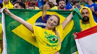 Mereka juga membawa bendera timnas Brasil saat hadir di stadion. Foto Olimpik/NurPhoto/Getty Images  