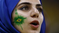 Suporter cantik timnas Brasil dengan lukisan bendera Brasil di pipinya saat bersorak memberikan dukungan. Reuters/Amanda Perobelli  