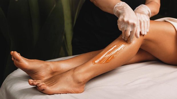 Young caucasian girl having epilation procedures with sugar at spa salon