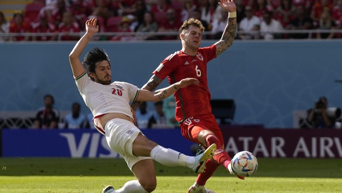 Irans Sardar Azmoun, left, and Wales Joe Rodon vie for the ball during the World Cup group B soccer match between Wales and Iran, at the Ahmad Bin Ali Stadium in Al Rayyan , Qatar, Friday, Nov. 25, 2022. (AP Photo/Alessandra Tarantino)