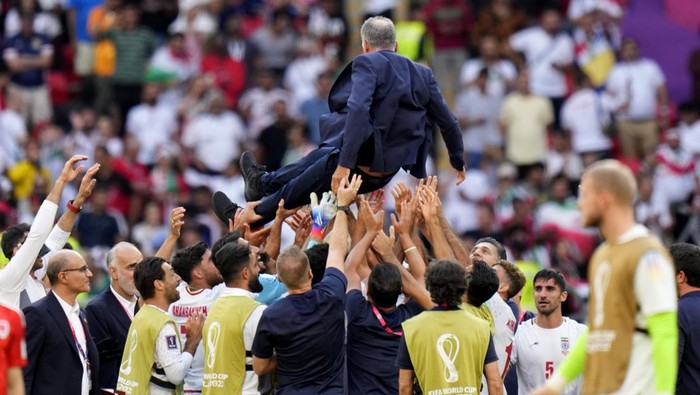 Players throw Irans head coach Carlos Queiroz in air as they celebrate after their win in the World Cup group B soccer match between Wales and Iran, at the Ahmad Bin Ali Stadium in Al Rayyan, Qatar, Friday, Nov. 25, 2022. (AP Photo/Alessandra Tarantino)