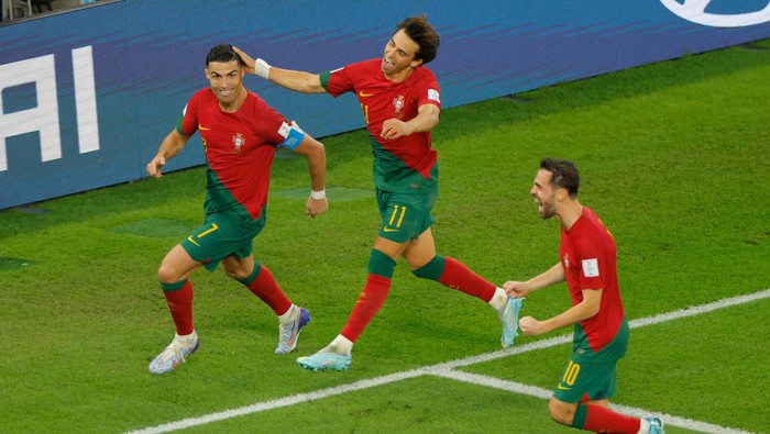 Portugals forward #07 Cristiano Ronaldo celebrates with Portugals forward #11 Joao Felix and Portugals midfielder #10 Bernardo Silva after scoring his teams first goal from the penalty spot during the Qatar 2022 World Cup Group H football match between Portugal and Ghana at Stadium 974 in Doha on November 24, 2022. (Photo by Odd ANDERSEN / AFP) (Photo by ODD ANDERSEN/AFP via Getty Images)
