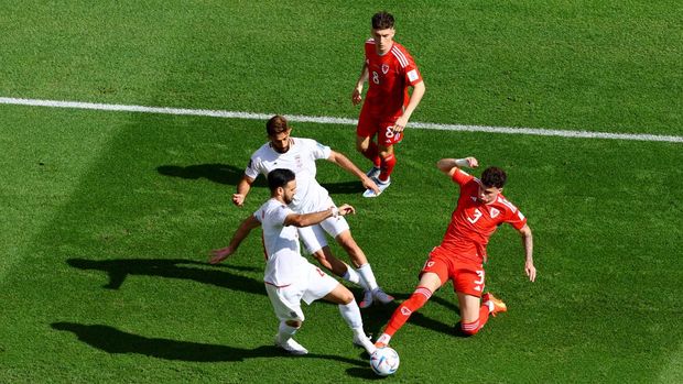 Soccer Football - FIFA World Cup Qatar 2022 - Group B - Wales v Iran - Ahmad Bin Ali Stadium, Al Rayyan, Qatar - November 25, 2022  Wales' Neco Williams and Harry Wilson in action with Iran's Ali Gholizadeh REUTERS/Fabrizio Bensch
