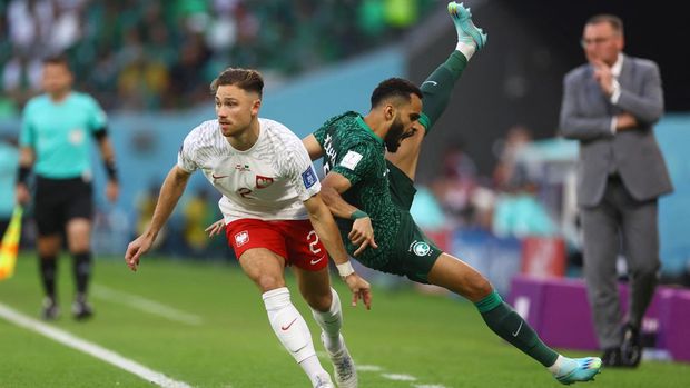 Soccer Football - FIFA World Cup Qatar 2022 - Group C - Poland v Saudi Arabia - Education City Stadium, Al Rayyan, Qatar - November 26, 2022 Poland's Matty Cash in action with Saudi Arabia's Mohammed Al Burayk REUTERS/Kai Pfaffenbach
