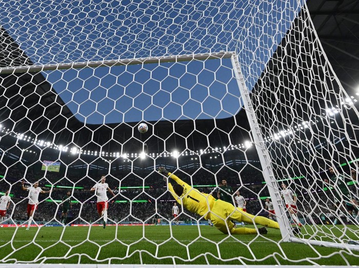 TOPSHOT - Poland's goalkeeper #01 Wojciech Szczesny stops a shot by Saudi Arabia's defender #06 Mohammed Al-Breik (R) after deflecting a penalty kick by Saudi Arabia's midfielder #10 Salem Al-Dawsari during the Qatar 2022 World Cup Group C football match between Poland and Saudi Arabia at the Education City Stadium in Al-Rayyan, west of Doha on November 26, 2022. (Photo by ANDREJ ISAKOVIC / AFP) (Photo by ANDREJ ISAKOVIC/AFP via Getty Images)