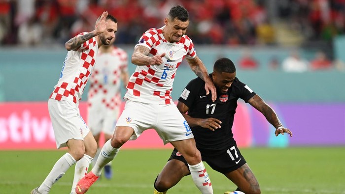 DOHA, QATAR - NOVEMBER 27: Cyle Larin of Canada is challenegd by Dejan Lovren of Croatia during the FIFA World Cup Qatar 2022 Group F match between Croatia and Canada at Khalifa International Stadium on November 27, 2022 in Doha, Qatar. (Photo by David Ramos - FIFA/FIFA via Getty Images)