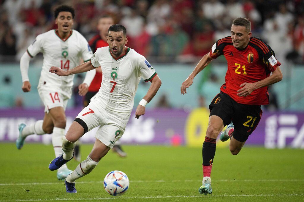 Morocco's Hakim Ziyech, center, and Belgium's Timothy Castagne challenge for the ball besides Morocco's Zakaria Aboukhlal, background left, during the World Cup group F soccer match between Belgium and Morocco, at the Al Thumama Stadium in Doha, Qatar, Sunday, Nov. 27, 2022. (AP Photo/Christophe Ena)