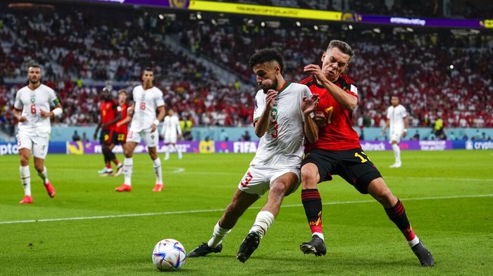 Belgium's Leandro Trossard, left, and Morocco's Noussair Mazraoui clash during a World Cup group F soccer match at the Al Thumama Stadium in Doha, Qatar, Sunday, Nov. 27, 2022. (AP Photo/Manu Fernandez)