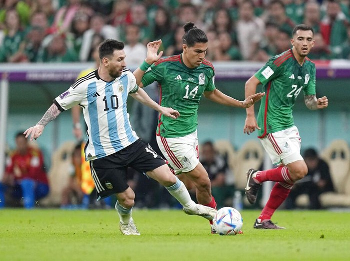 Argentina's Lionel Messi, left, challenges for the ball with Mexico's Erick Gutierrez, center, during the World Cup group C soccer match between Argentina and Mexico, at the Lusail Stadium in Lusail, Qatar, Saturday, Nov. 26, 2022. (AP Photo/Ariel Schalit)