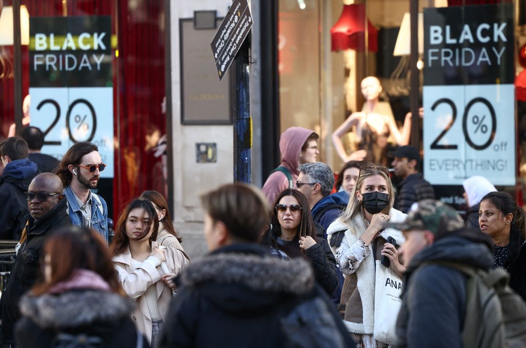 People walk past Black Friday signage in shop windows during Black Friday on Oxford Street in London, Britain, November 25, 2022. REUTERS/Henry Nicholls