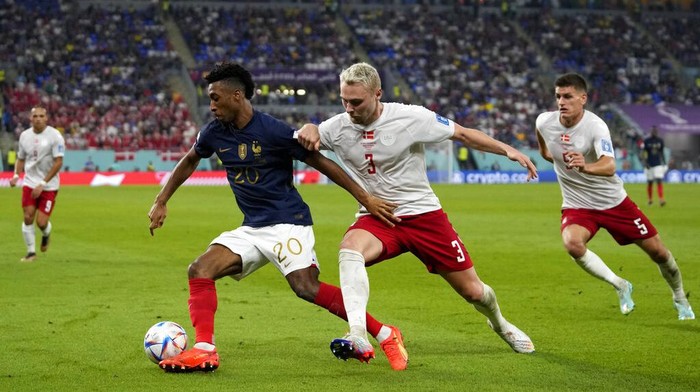 Denmark's Victor Nelsson, right, challenges France's Kingsley Coman during the World Cup group D soccer match between France and Denmark, at the Stadium 974 in Doha, Qatar, Saturday, Nov. 26, 2022. (AP Photo/Thanassis Stavrakis)