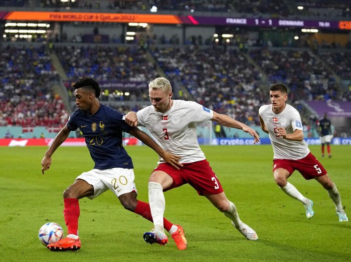 Denmark's Victor Nelsson, right, challenges France's Kingsley Coman during the World Cup group D soccer match between France and Denmark, at the Stadium 974 in Doha, Qatar, Saturday, Nov. 26, 2022. (AP Photo/Thanassis Stavrakis)