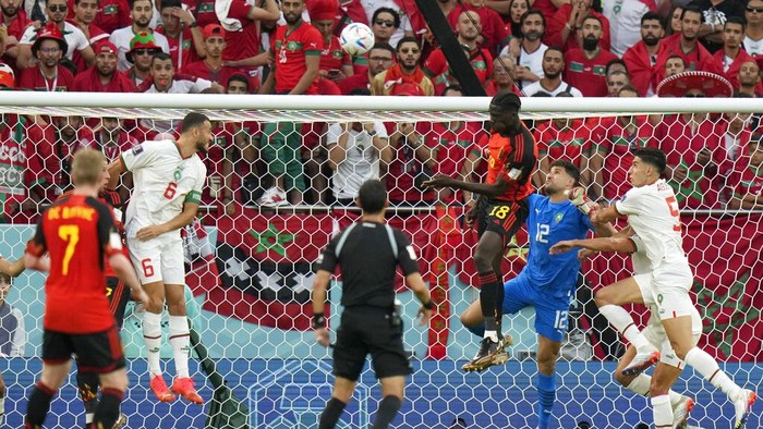 Belgiums Amadou Onana, center left, fights for a header with Moroccos goalkeeper Munir Mohamedi, center right, during the World Cup group F soccer match between Belgium and Morocco, at the Al Thumama Stadium in Doha, Qatar, Sunday, Nov. 27, 2022. (AP Photo/Alessandra Tarantino)