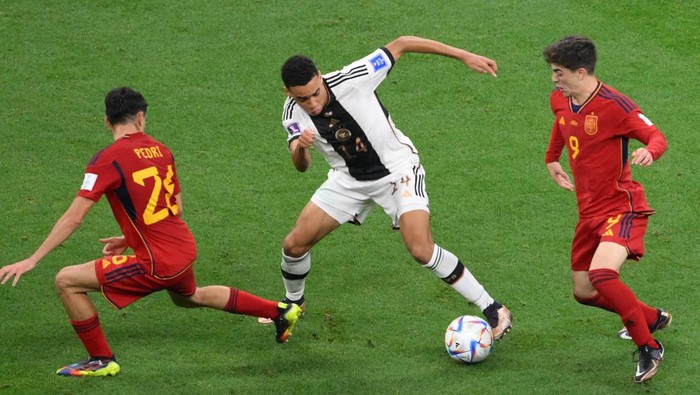 Jamal Musiala, Gavi, Pedri Germany's midfielder #14 Jamal Musiala is challenged by Spain's midfielder #26 Pedri and Spain's midfielder #09 Gavi during the Qatar 2022 World Cup Group E football match between Spain and Germany at the Al-Bayt Stadium in Al Khor, north of Doha on November 27, 2022. (Photo by NICOLAS TUCAT / AFP) (Photo by NICOLAS TUCAT/AFP via Getty Images)