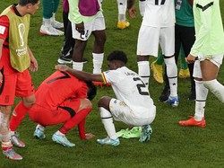 Son Heung-min tertunduk dan pemain Ghana berusaha menenangkannya. (Foto: AP/Ebrahim Noroozi)
