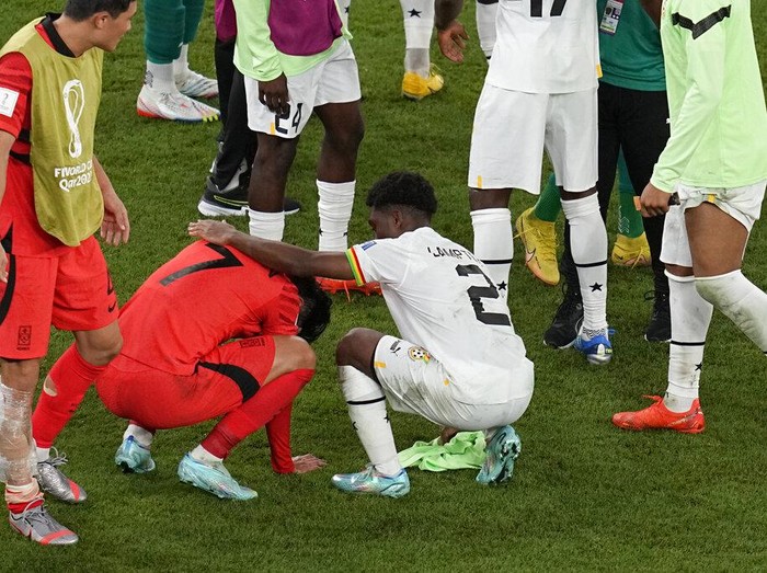 South Korea's Son Heung-min, second left, is comforted by Ghana's Tariq Lamptey after South Korea lost the World Cup group H soccer match against Ghana, at the Education City Stadium in Al Rayyan, Qatar, Monday, Nov. 28, 2022. (AP Photo/Ebrahim Noroozi)
