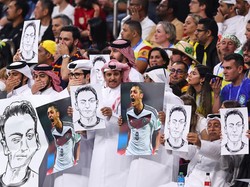 Fans asal Qatar membawa foto dan gambar Oezil dalam laga Spanyol vs Jerman, Senin 28 November 2022. (Foto: Getty Images/Robbie Jay Barratt - AMA)
