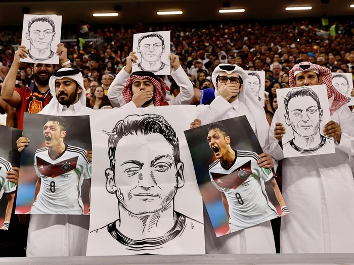 AL KHOR, QATAR - NOVEMBER 27: Fans hold photos and posters of Mesut Ozil of Medipol Basaksehir during the FIFA World Cup Qatar 2022 Group E match between Spain and Germany at Al Bayt Stadium on November 27, 2022 in Al Khor, Qatar. (Photo by Mohammed Dabbous/Anadolu Agency via Getty Images)