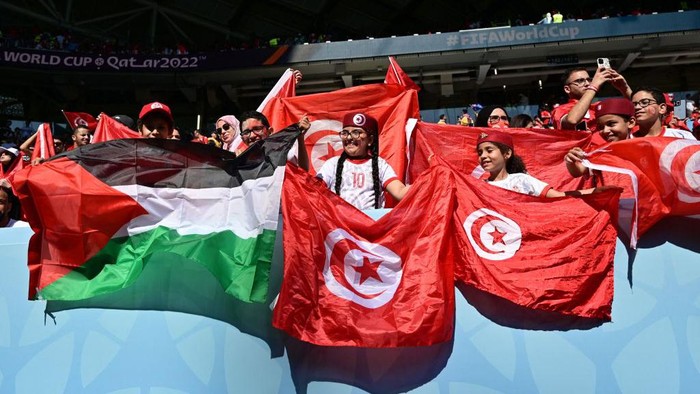 Fans of Tunisia with a Palestinian and Tunisian flags cheer on the stands ahead of the Qatar 2022 World Cup Group D football match between Tunisia and Australia at the Al-Janoub Stadium in Al-Wakrah, south of Doha on November 26, 2022. (Photo by MIGUEL MEDINA / AFP) (Photo by MIGUEL MEDINA/AFP via Getty Images)