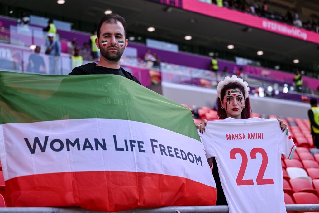 DOHA, QATAR - NOVEMBER 25: Fans of Iran protest with flags, banners with slogan Woman Life Freedom after death of Mahsa Amini for women's rights in Iran prior to the FIFA World Cup Qatar 2022 Group B match between Wales and IR Iran at Ahmad Bin Ali Stadium on November 25, 2022 in Doha, Qatar. (Photo by Harry Langer/DeFodi Images via Getty Images)