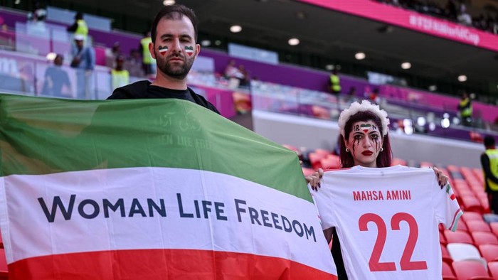 DOHA, QATAR - NOVEMBER 25: Fans of Iran protest with flags, banners with slogan Woman Life Freedom after death of Mahsa Amini for womens rights in Iran prior to the FIFA World Cup Qatar 2022 Group B match between Wales and IR Iran at Ahmad Bin Ali Stadium on November 25, 2022 in Doha, Qatar. (Photo by Harry Langer/DeFodi Images via Getty Images)