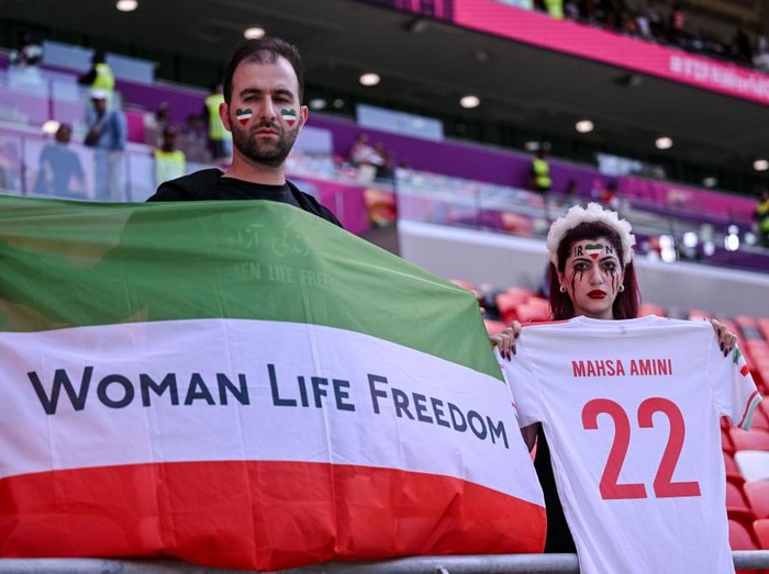 DOHA, QATAR - NOVEMBER 25: Fans of Iran protest with flags, banners with slogan Woman Life Freedom after death of Mahsa Amini for women's rights in Iran prior to the FIFA World Cup Qatar 2022 Group B match between Wales and IR Iran at Ahmad Bin Ali Stadium on November 25, 2022 in Doha, Qatar. (Photo by Harry Langer/DeFodi Images via Getty Images)