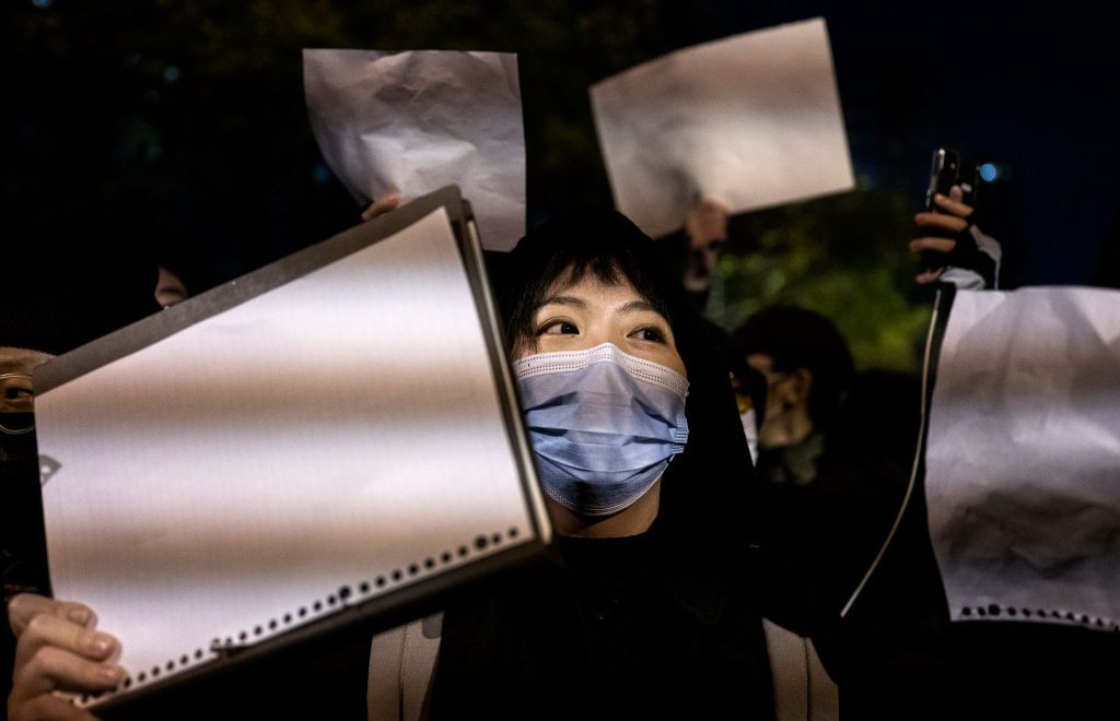 BEIJING, CHINA -NOVEMBER 27: Protesters hold up a white piece of paper against censorship as they march during a protest against Chinas strict zero COVID measures on November 27, 2022 in Beijing, China. Protesters took to the streets in multiple Chinese cities after a deadly apartment fire in Xinjiang province sparked a national outcry as many blamed COVID restrictions for the deaths. (Photo by Kevin Frayer/Getty Images)