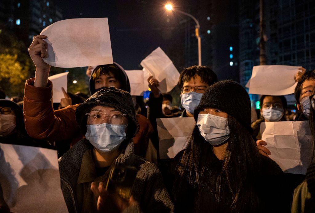 BEIJING, CHINA - NOVEMBER 27: Protesters hold up pieces of paper against censorship and China's strict zero COVID measures on November 27, 2022 in Beijing, China. Protesters took to the streets in multiple Chinese cities after a deadly apartment fire in Xinjiang province sparked a national outcry as many blamed COVID restrictions for the deaths. (Photo by Kevin Frayer/Getty Images)