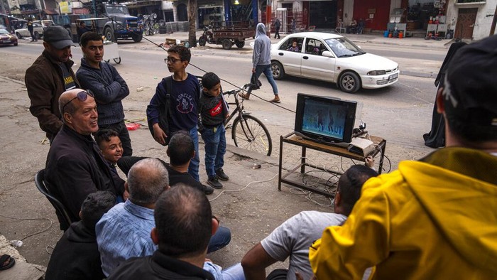 Begini Semarak Piala Dunia 2022 di Palestina Palestinians watch the live broadcast of the World Cup group H soccer match between South Korea and Ghana played in Qatar, in the street in Gaza City, Monday, Nov. 28, 2022. (AP Photo/Fatima Shbair)
