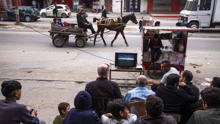 Palestinians watch the live broadcast of the World Cup group H soccer match between South Korea and Ghana played in Qatar, in the street in Gaza City, Monday, Nov. 28, 2022. (AP Photo/Fatima Shbair)
