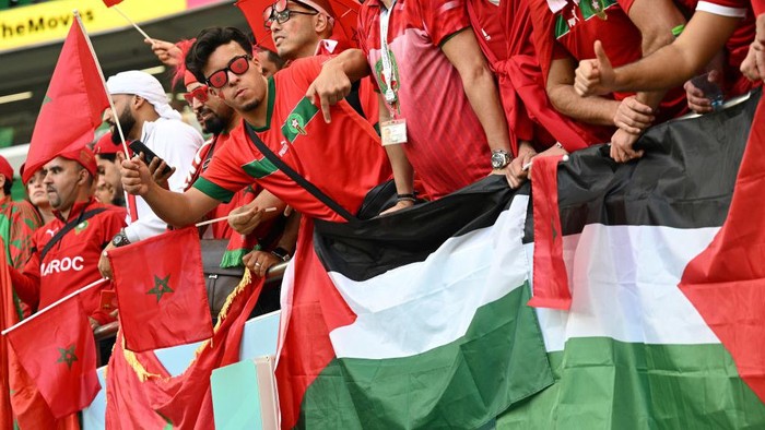 Dukungan untuk Palestina Menggema di Piala Dunia DOHA, QATAR - NOVEMBER 27: Fans of Morocco show their support to the Palestinian flag during the FIFA World Cup Qatar 2022 Group F match between Belgium and Morocco at Al Thumama Stadium on November 27, 2022 in Doha, Qatar. (Photo by Lionel Hahn/Getty Images)
