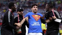 Pria itu berada di lapangan selama sekitar 30 detik, sebelum akhirnya dikawal oleh petugas keamanan. Di kaus pria itu juga bertuliskan kata-kata Selamatkan Ukraina di bagian depan. (Jean Catuffe/Getty Images)  