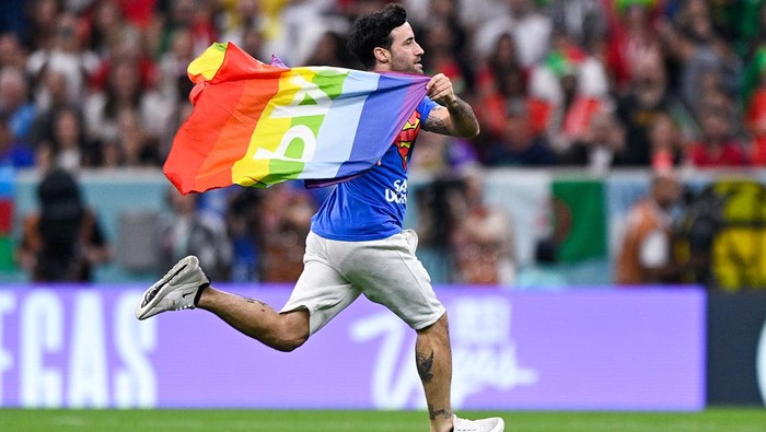 Pria Ini Nekat Kibarkan Bendera Pelangi di Lapangan Piala Dunia LUSAIL CITY, QATAR - NOVEMBER 28: A pitch invader wearing a shirt reading