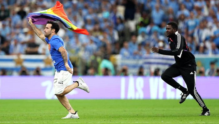 LUSAIL CITY, QATAR - NOVEMBER 28: A pitch invader wearing a shirt reading 