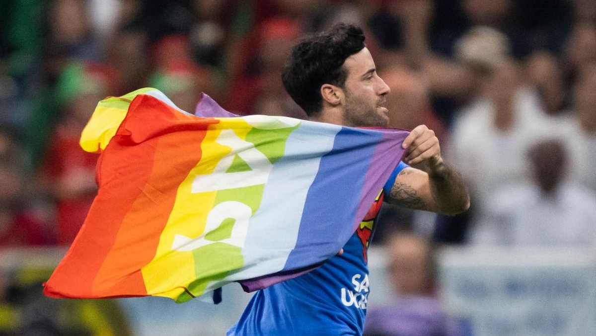 Aksi Mario Ferri menerobos lapangan dan membawa bendera pelangi LGBT di laga Portugal vs Uruguay di Piala Dunia 2022. (Foto: Sebastian Frej/MB Media/Getty Images)