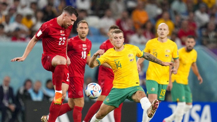 Australias Riley McGree, center, is challenged by Denmarks Pierre-Emile Hojbjerg, left, during the World Cup group D soccer match between Australia and Denmark, at the Al Janoub Stadium in Al Wakrah, Qatar, Wednesday, Nov. 30, 2022. (AP Photo/Aijaz Rahi)