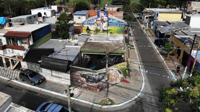 Semarak Piala Dunia di Kampung Halaman Messi Artists Marlene Zuriaga and Lisandro Urteaga finish the details of a mural depicting Argentine football star Lionel Messi in his childhood home in Rosario, Argentina, on November 26, 2022. (Photo by MARCELO MANERA / AFP) (Photo by MARCELO MANERA/AFP via Getty Images)