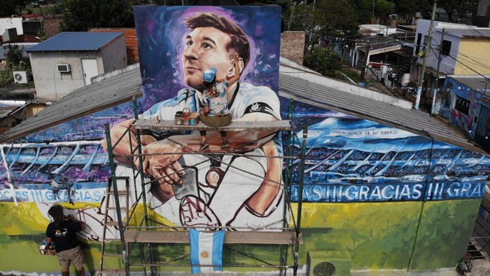 Artists Marlene Zuriaga and Lisandro Urteaga finish the details of a mural depicting Argentine football star Lionel Messi in his childhood home in Rosario, Argentina, on November 26, 2022. (Photo by MARCELO MANERA / AFP) (Photo by MARCELO MANERA/AFP via Getty Images)