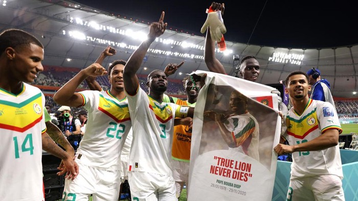 DOHA, QATAR - NOVEMBER 29: Senegal players applaud fans with a banner of Papa Bouba Diop, on the 2nd anniversary of his death, after their 2-1 victory in the FIFA World Cup Qatar 2022 Group A match between Ecuador and Senegal at Khalifa International Stadium on November 29, 2022 in Doha, Qatar. (Photo by Buda Mendes/Getty Images)