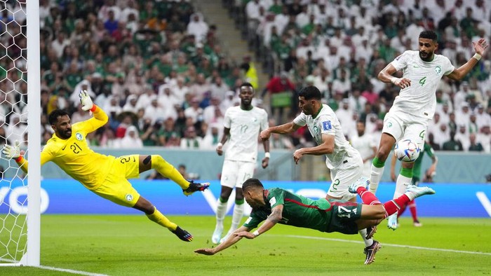 Mexicos Orbelin Pineda, center down, makes an attempt to score past Saudi Arabias goalkeeper Mohammed Al-Owais, left, during the World Cup group C soccer match between Saudi Arabia and Mexico, at the Lusail Stadium in Lusail, Qatar, Wednesday, Nov. 30, 2022. (AP Photo/Manu Fernandez)
