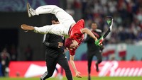 Saat babak kedua berjalan sekitar 25 menit, seorang suporter Tunisia masuk ke lapangan. Dia berlari sambil salto-salto dengan membawa bendera Palestina. (Foto: AP/Martin Meissner)
